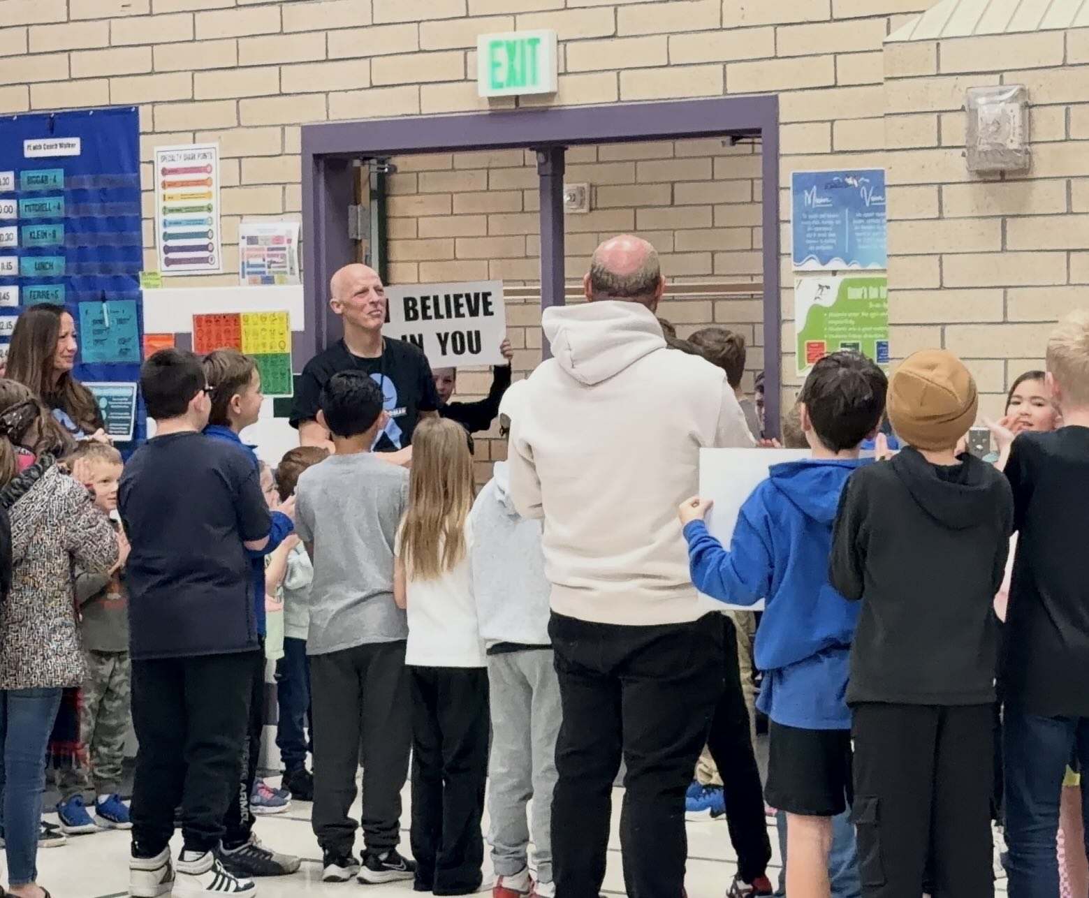 Students and adults holding belief signs at a school rally
