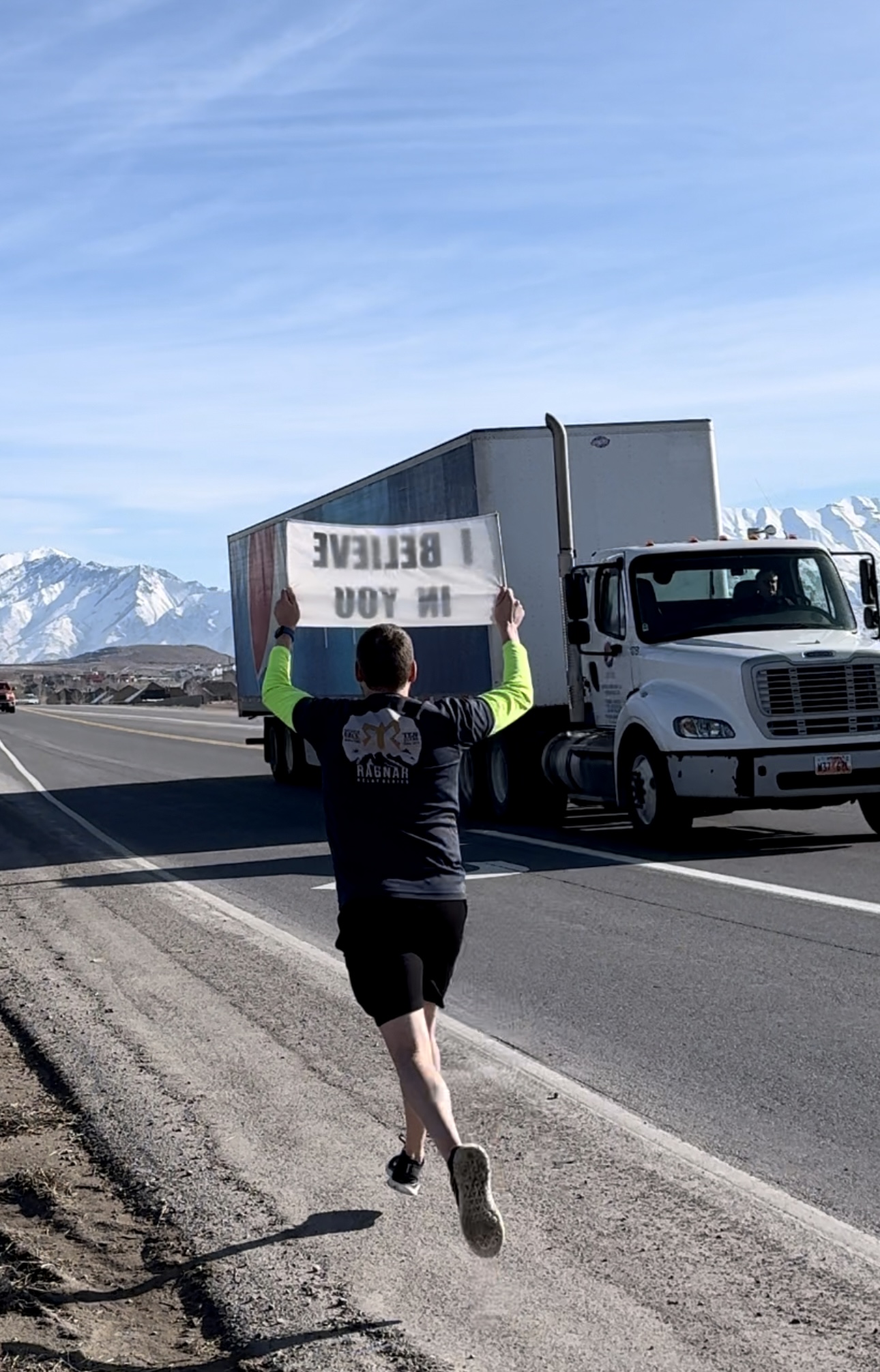 Person showing I Believe In You sign to truck driver